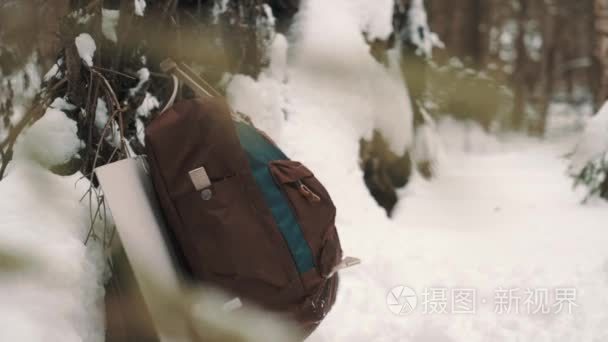 挂在雪盖森林树枝上的旅行背包视频