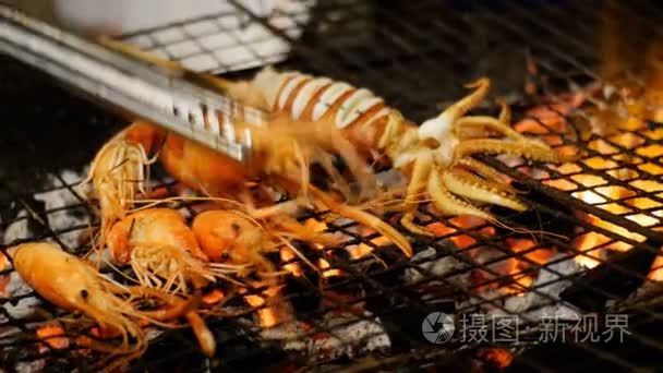 鱿鱼煮在烧烤炉篦在夜间食品市场,泰国街头食品。泰国