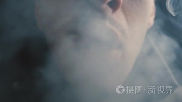 关闭一个残酷的人在夜间吸烟一支香烟慢动作