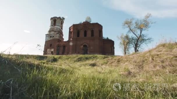 老砖房子谷仓或寺庙在夏天领域。视频.黎明时的建筑物和树。五颜六色的蓝天与云彩。春天的风景。乡村风光。阳光透过树的光芒