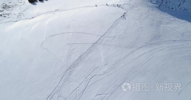 落后空中俯视冬季雪山滑雪场与人们在晴天。在阿尔卑斯山之上雪季节制订者. 4 k 飞行建立射击视频