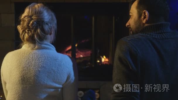 坐在火炉前的已婚夫妇视频