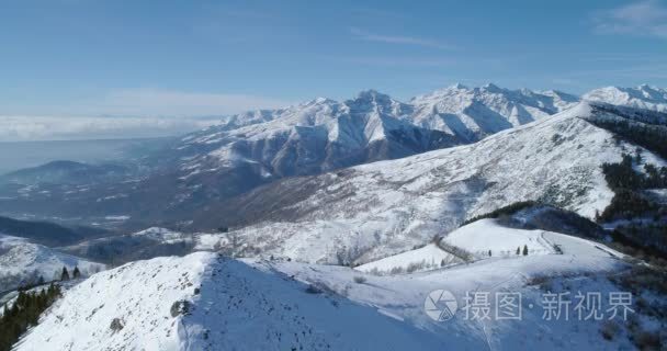 在阳光明媚的日子里, 在冬季雪山和滑雪场上向前空中俯视。揭示山谷。阿尔卑斯山雪季节制订者 4 k 飞行建立射击