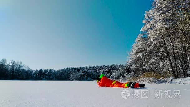 摄影师躺在冰冻湖的表面上视频