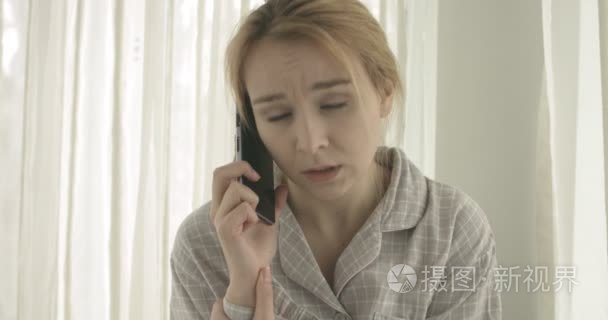 美丽的女人在家里谈论手机视频