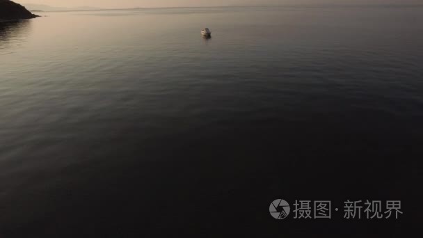 夕阳下宁静的大海中空船鸟瞰视频