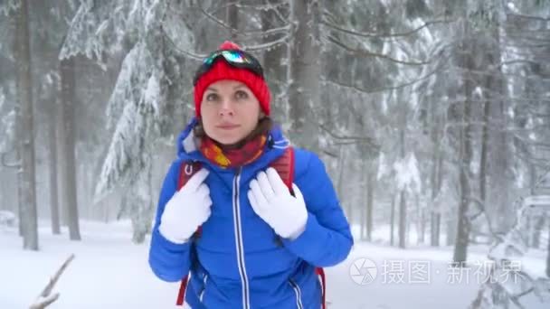 旅游女孩走在一个冬天积雪覆盖的针叶林在山上, 并伸出她的同伴帮助她。严寒天气