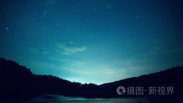 湖在晚上timelapse。视频.夜空 timelapse 与奔跑的星星。在山上湖边的一棵松树林的剪影上, 看到了银河系的星星