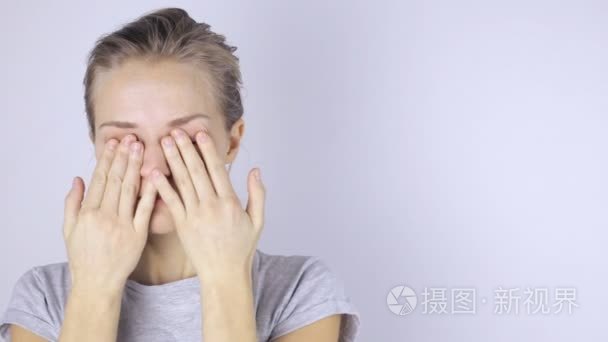 年轻美丽的女人揉她的眼睛视频