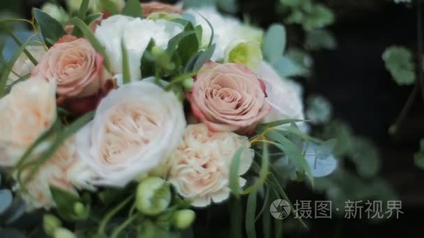 婚礼花束的玫瑰和康乃馨。婚礼那天的新娘花束。花束不同的花朵。美丽的粉红色  奶油和白色的花朵花束