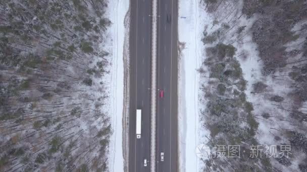 在冬季公路上查看汽车交通。汽车和卡车驾驶在冬天路