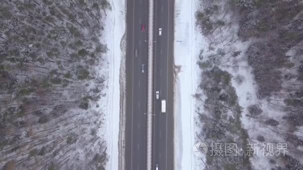 冬季交通雪高速公路鸟瞰图。在暴雪路上行驶的汽车