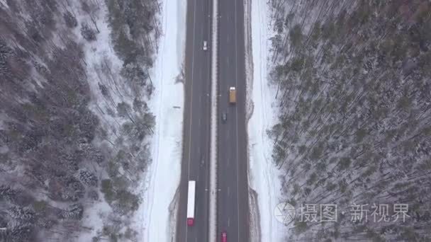 空中风景车驾驶在冬天高速公路通过雪森林