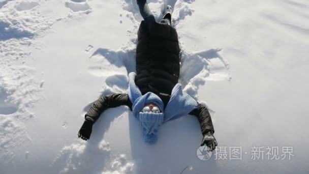 女孩跌倒和谎言在雪在蓝色帽子视频