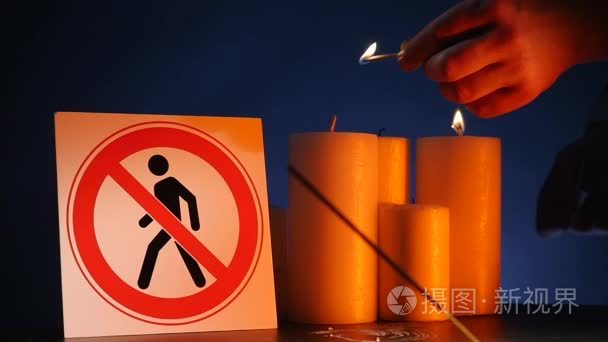 许多烧光蜡蜡烛与挥动黄色火焰与标志为人入口禁止在黑背景。圆厚的燃烧棒庆祝活动和闪电