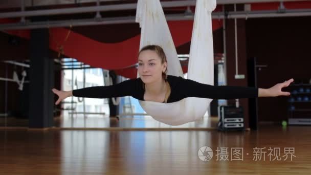 在飞行瑜伽期间  女人在地板上的空气吊床上摇摆