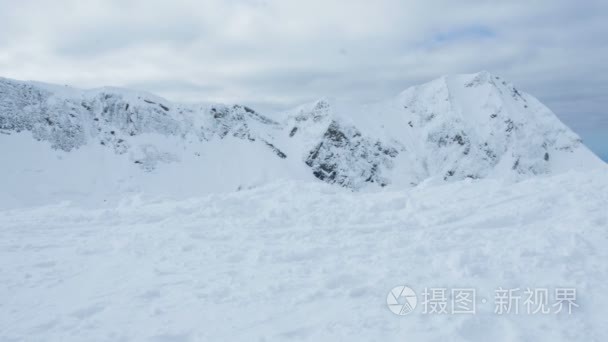 一个穿着鲜艳西装的滑雪者来到山顶  4k