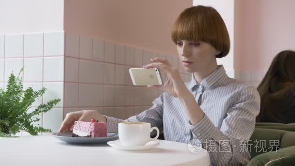 年轻漂亮的红头发女孩在咖啡馆里做蛋糕的照片。今天的问题, 社交网络。60 fps视频