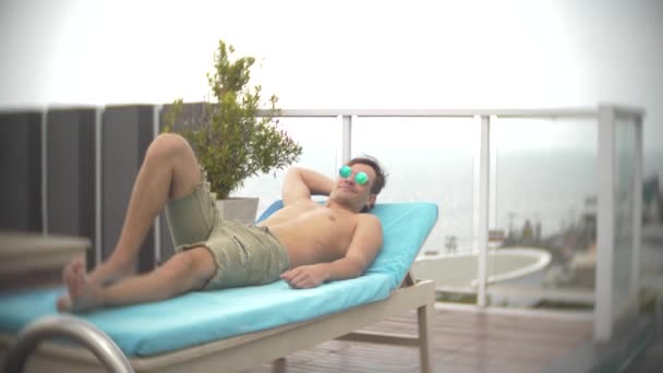 一个男人放松 在屋顶上的躺椅上晒日光浴 俯瞰大海 4k 背景模糊mp4格式视频下载 正版视频编号01mwz3 摄图新视界视频库