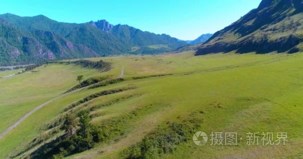 在晴朗的夏日清晨  空中的乡村山路和草地。沥青公路与河道