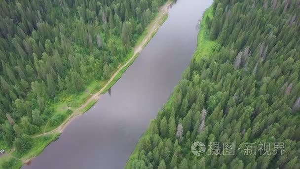 河流在森林中流淌。鸟瞰图。剪辑.在夏天的时候鸟瞰森林湖。白云越过地平线。一条河流的绿色景观鸟瞰图