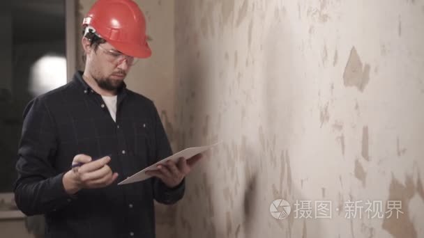主建设者在维修工程中检查墙面覆盖物的质量