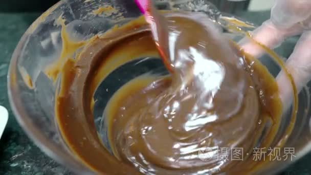巧克力糊的特写被混合在厨房的玻璃碗里