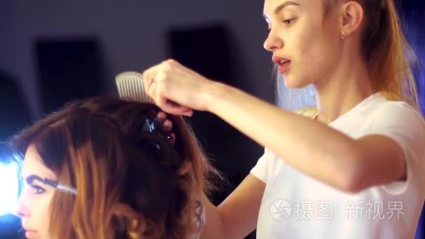 年轻的发型师女孩给女士做发型视频