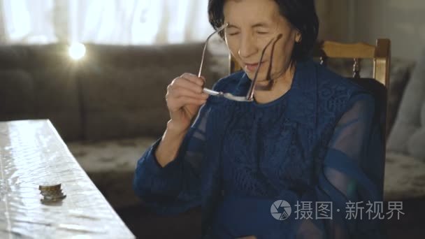 微笑的老太太的肖像戴上眼镜  看着相机