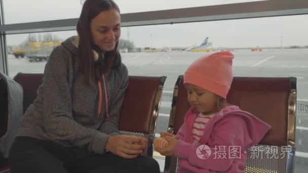 母亲和女儿在机场。小女孩普通话在等候大厅