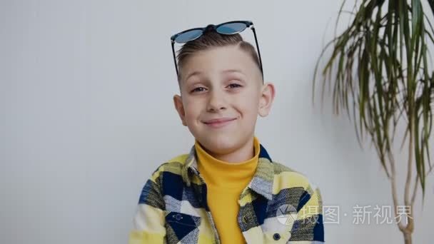 蓝眼睛的年轻男孩的肖像, 看着相机微笑着, 用他的手显示, 一切都好.