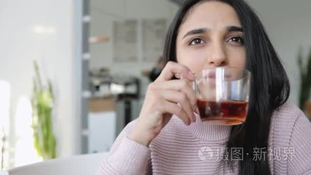 美丽的女人在一家咖啡馆喝茶视频