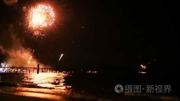 明亮的金色烟花在夜空的海面上爆炸