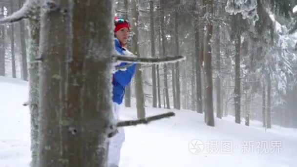孤独的旅游女孩走在一个冬天积雪覆盖的针叶林在山上。严寒天气