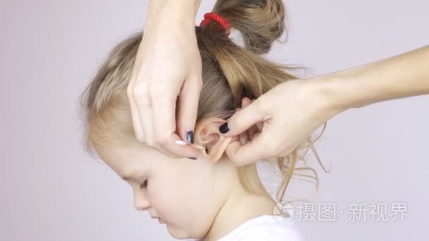 妇女清洁她的女儿耳朵用棉签视频