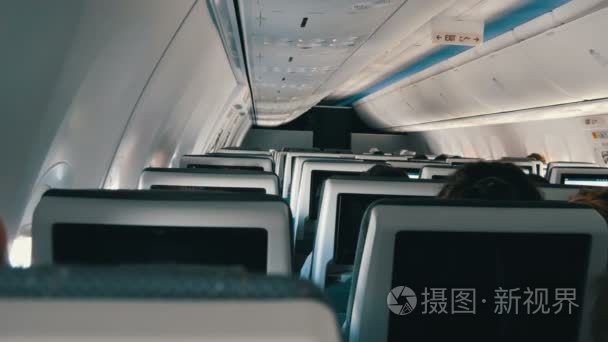 乘客在舒适的位子飞机与在屏幕在椅子