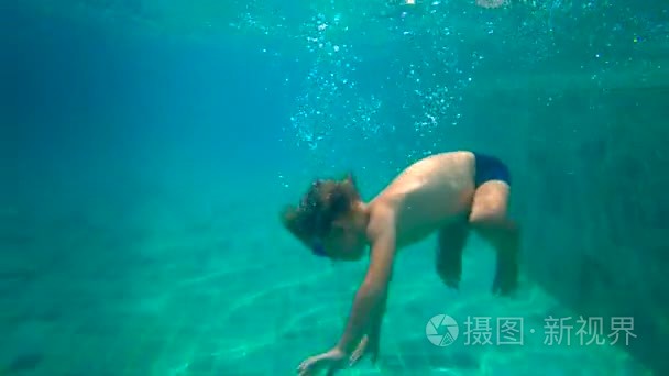 ultrahd slowmotion 水下的一个小男孩学习如何在游泳池游泳。蹒跚学步的男孩潜入水池, 从底部拉出石块。视频