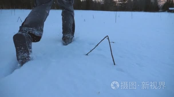 后面的看不到的家伙在森林边缘的雪草地上慢跑。年轻人晚上在雪地上奔跑  在冬季旅行中享受自由。关闭慢速运动