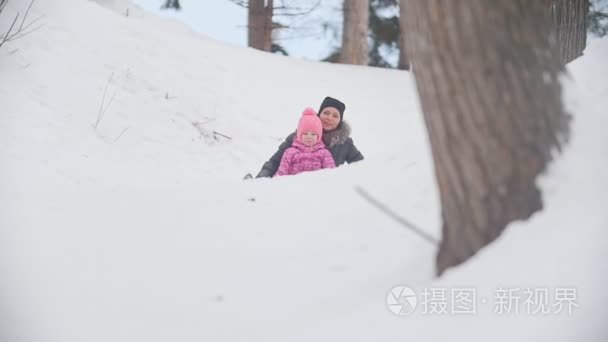 妈妈在公园里和孩子玩雪橇视频