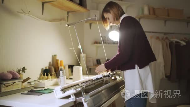 家庭车间针织机工作的年轻女子视频