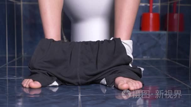 坐在马桶里, 肚子疼的男人的脚.