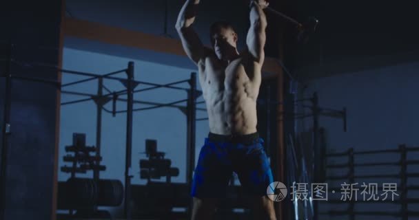 人做 crossfit 健身操用锤子在健身房