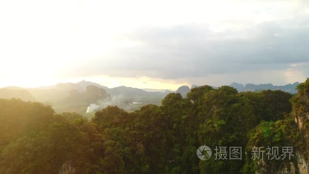 空中.电影风格的视频令人敬畏的景观在泰国。雨云  山和绿色视野在日落。相机从下到上和山后移动缓慢