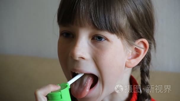 一个小女孩洒在她的嘴里喷出喉咙和感冒病短视频