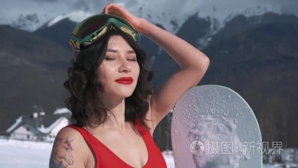 漂亮的滑雪板女孩假扮相机视频