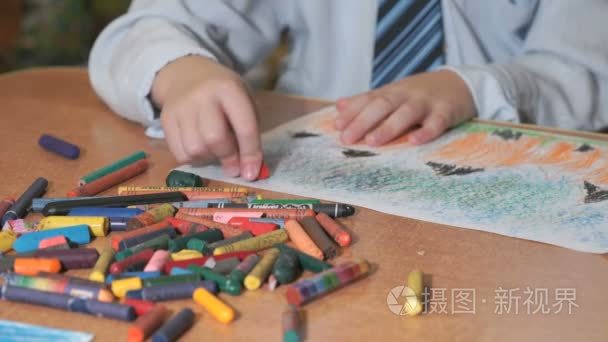 男孩用彩色粉笔和铅笔画画视频
