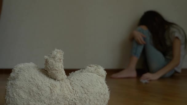 一个绝望的孩子在忧郁中坐在他房间的墙上, 试图自杀.