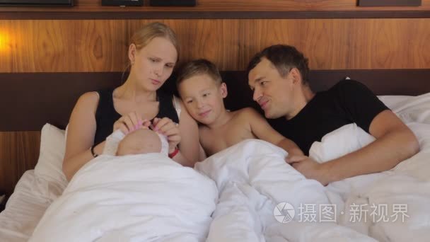 快乐的父母与孩子一起躺在床上视频