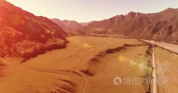 在晴朗的夏日清晨  空中的乡村山路和草地。沥青公路与河道