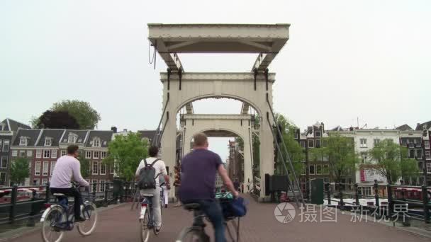 沿着阿姆斯特丹的 Magere Brug 骑自行车和徒步旅行者